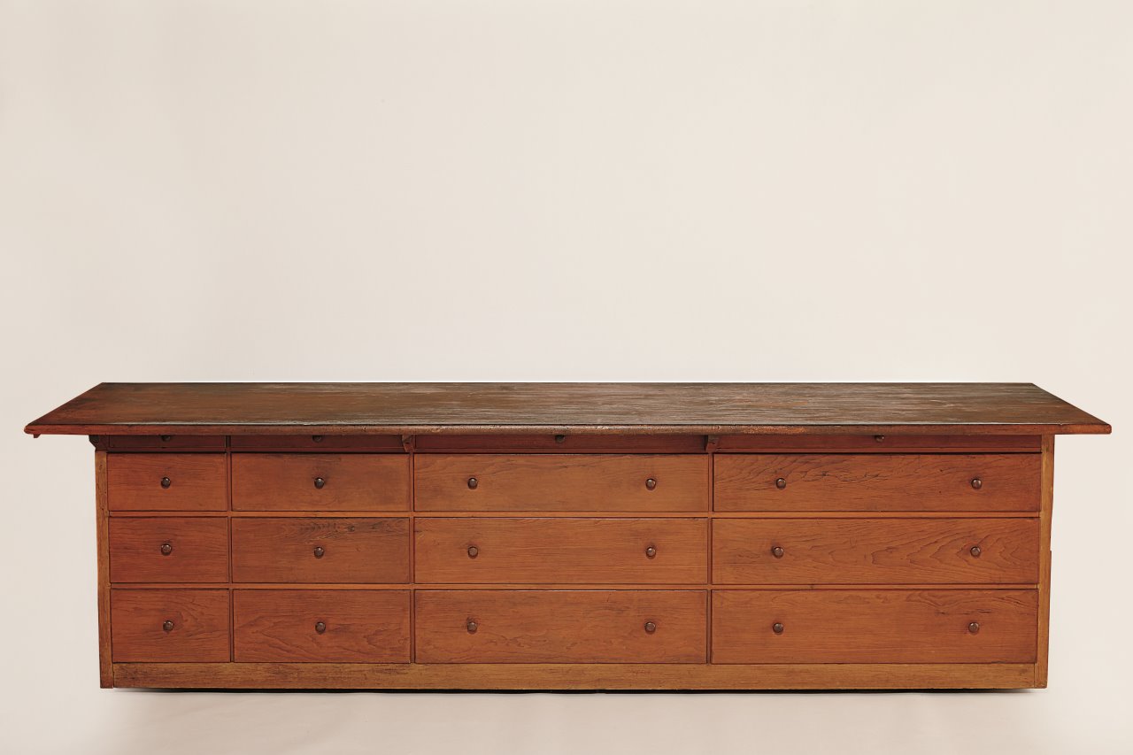 A wooden dresser with drawers on top.