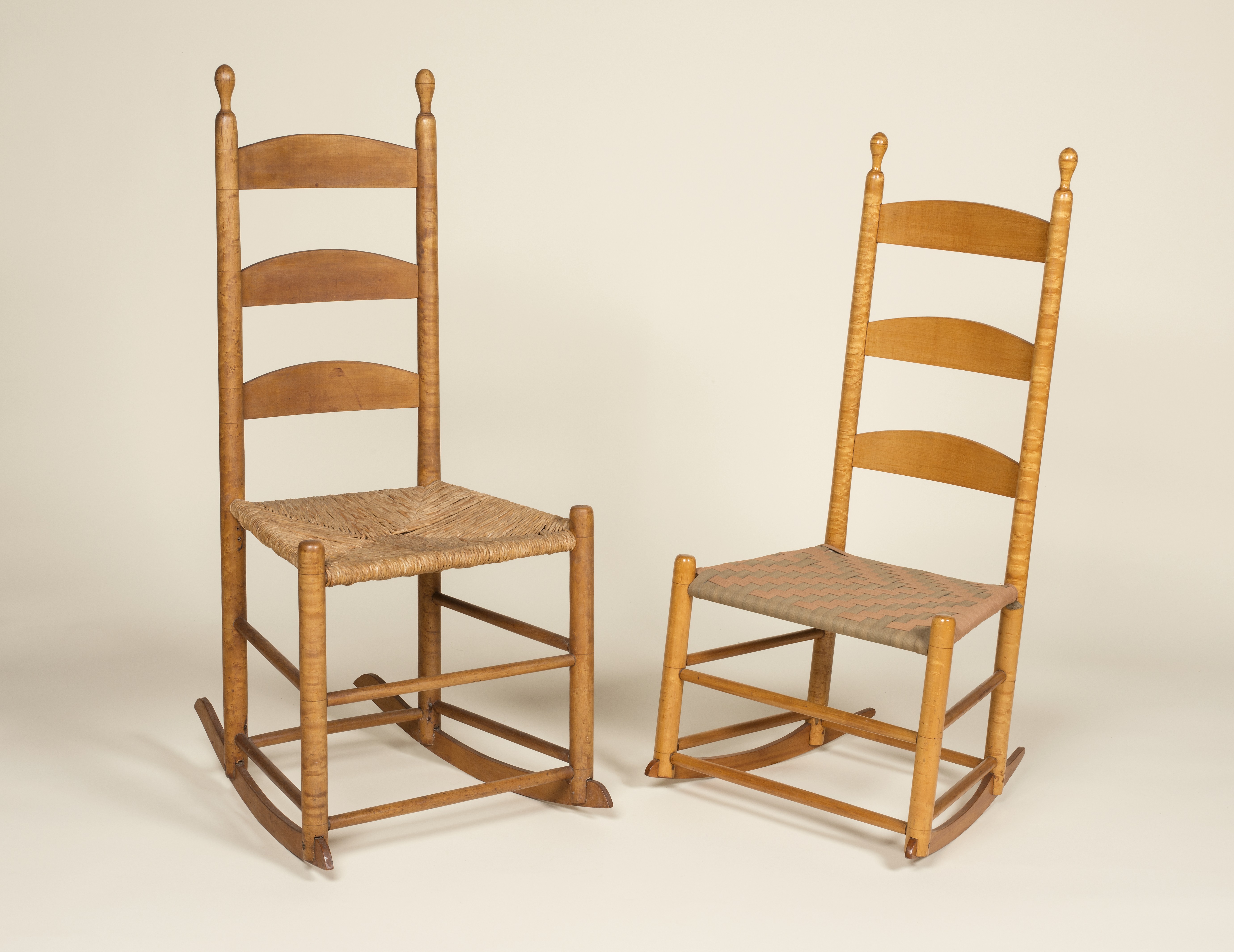 A pair of rocking chairs on a white background.