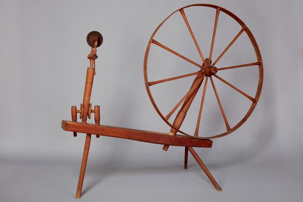 A spinning wheel with a wooden handle.
