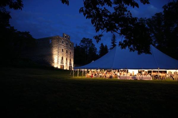 A tent is set up in front of a castle at night.
