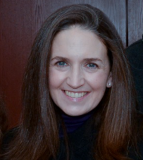 A woman with long brown hair smiling for the camera.