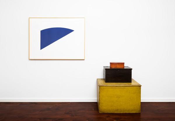 A blue painting and a yellow box in an empty room.