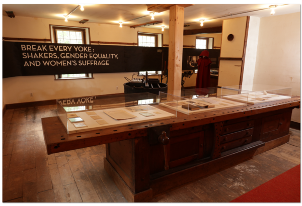 A room with a wooden table and a display case.