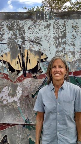 A woman standing in front of a wall with butterflies on it.