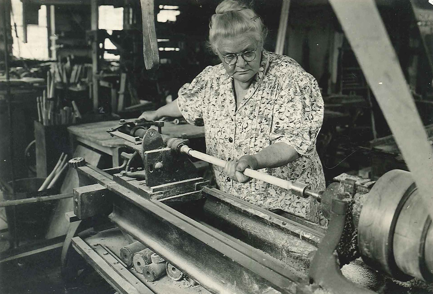 A woman working on a lathe.