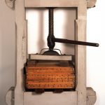 A wooden press with a wooden box on it.