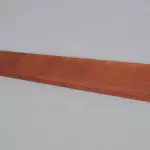 A piece of wood on a grey surface.