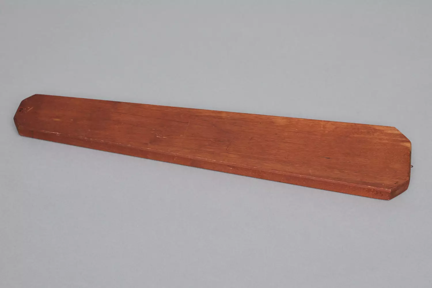 A piece of wood on a grey surface.
