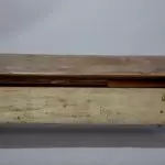An old wooden table with a drawer on it.