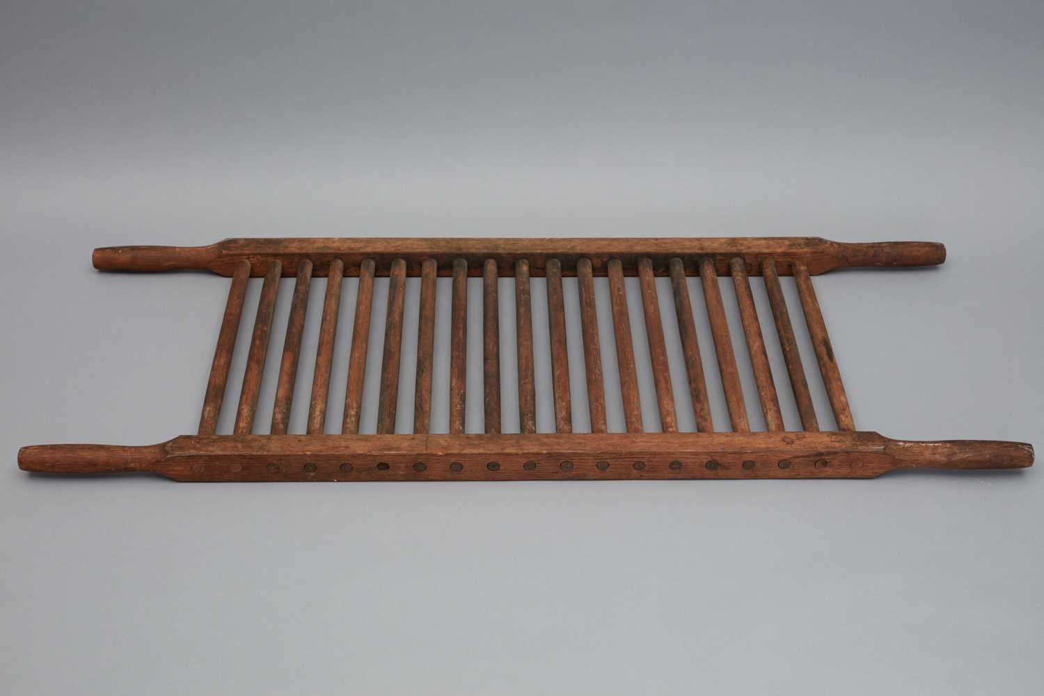 A wooden tray with a wooden handle.