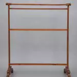 A wooden clothes rack on a gray background.