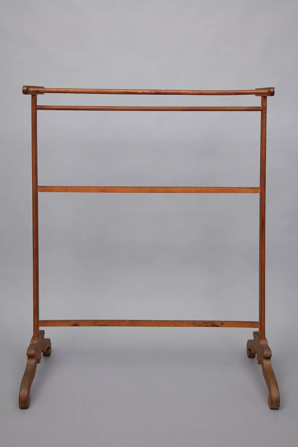 A wooden clothes rack on a gray background.