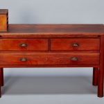 A small wooden chest of drawers with a box on top.