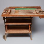 An old wooden workbench with a green top.