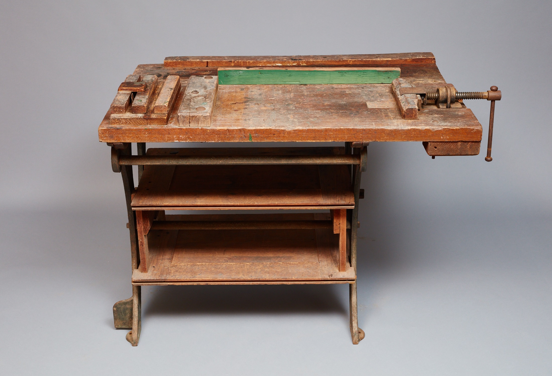 An old wooden workbench with a green top.