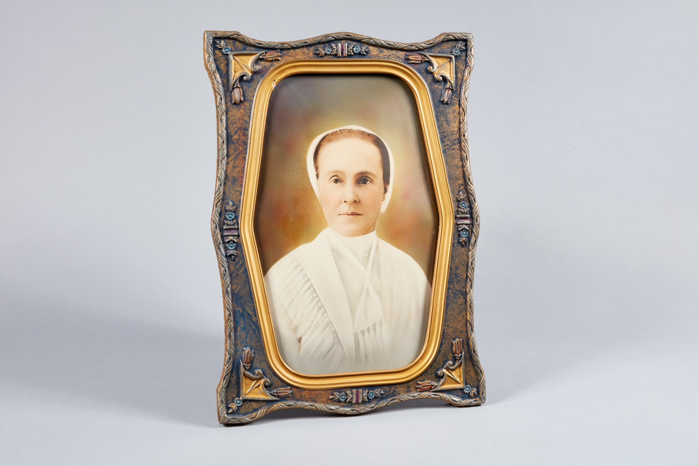 A portrait of a woman in an ornate frame.