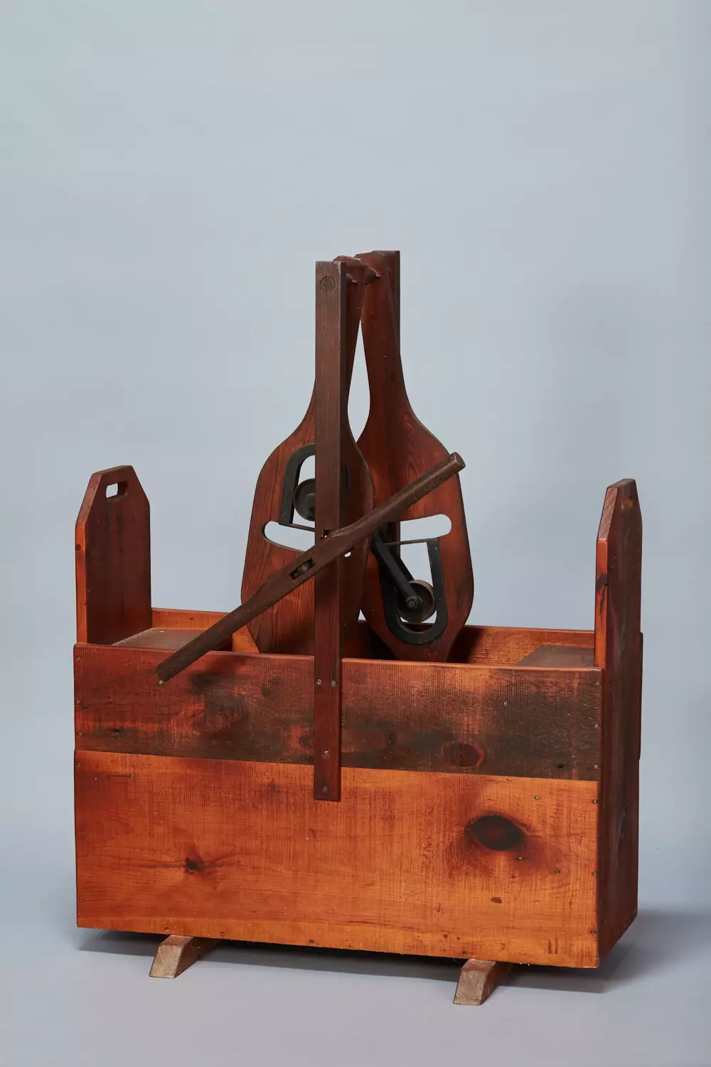 A wooden box with a pair of shoes in it.