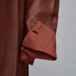 An image of a brown jacket with a pocket on it.