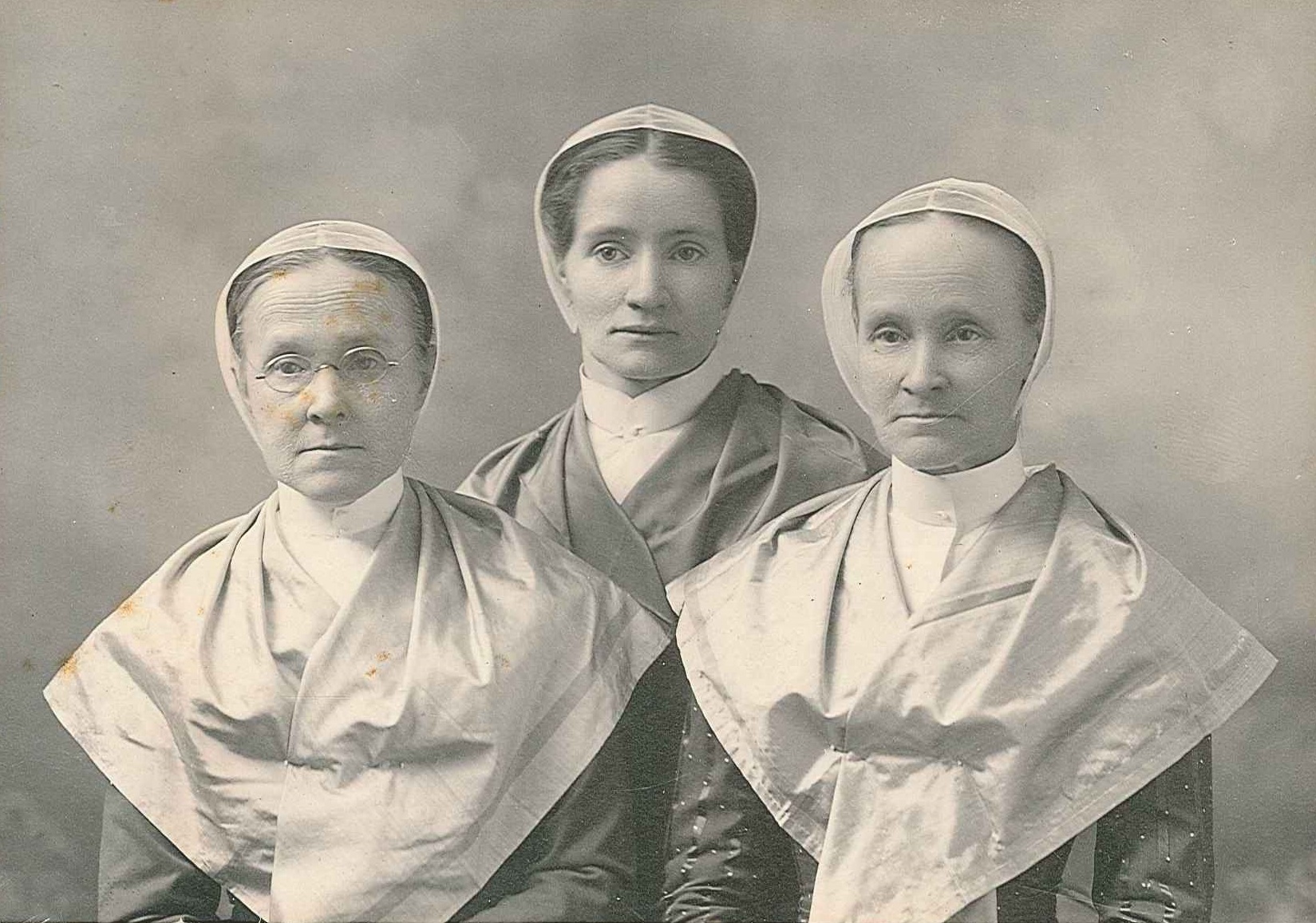 Three nuns posing for an old photo.