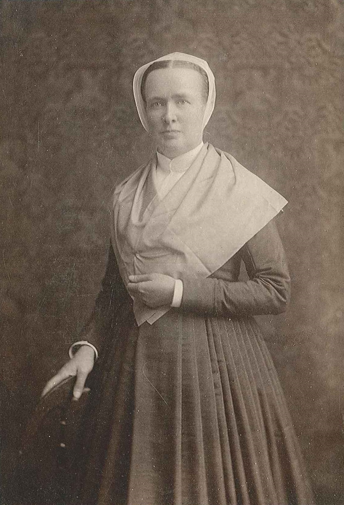 An old photo of a woman in a dress.