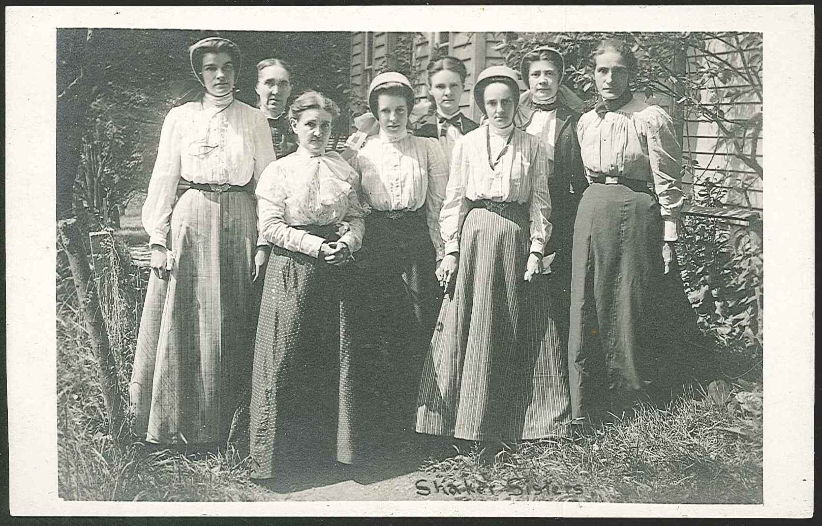 A group of women standing in front of a house.