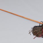 A wooden broom with a wooden handle.