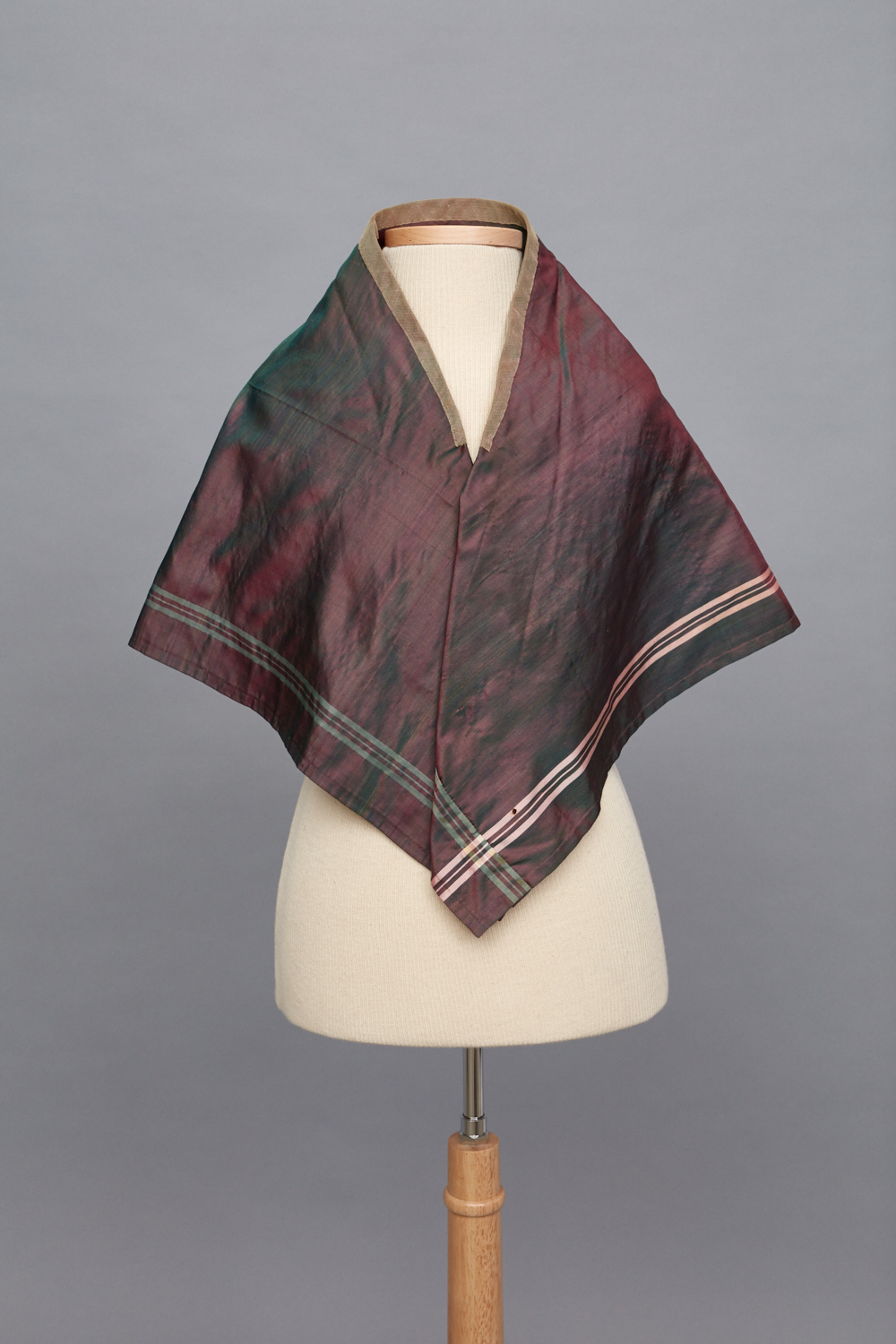 A red and green silk scarf on a mannequin.