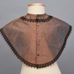 A brown shawl with black lace trim.