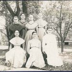 A group of women in dresses posing for a photo.