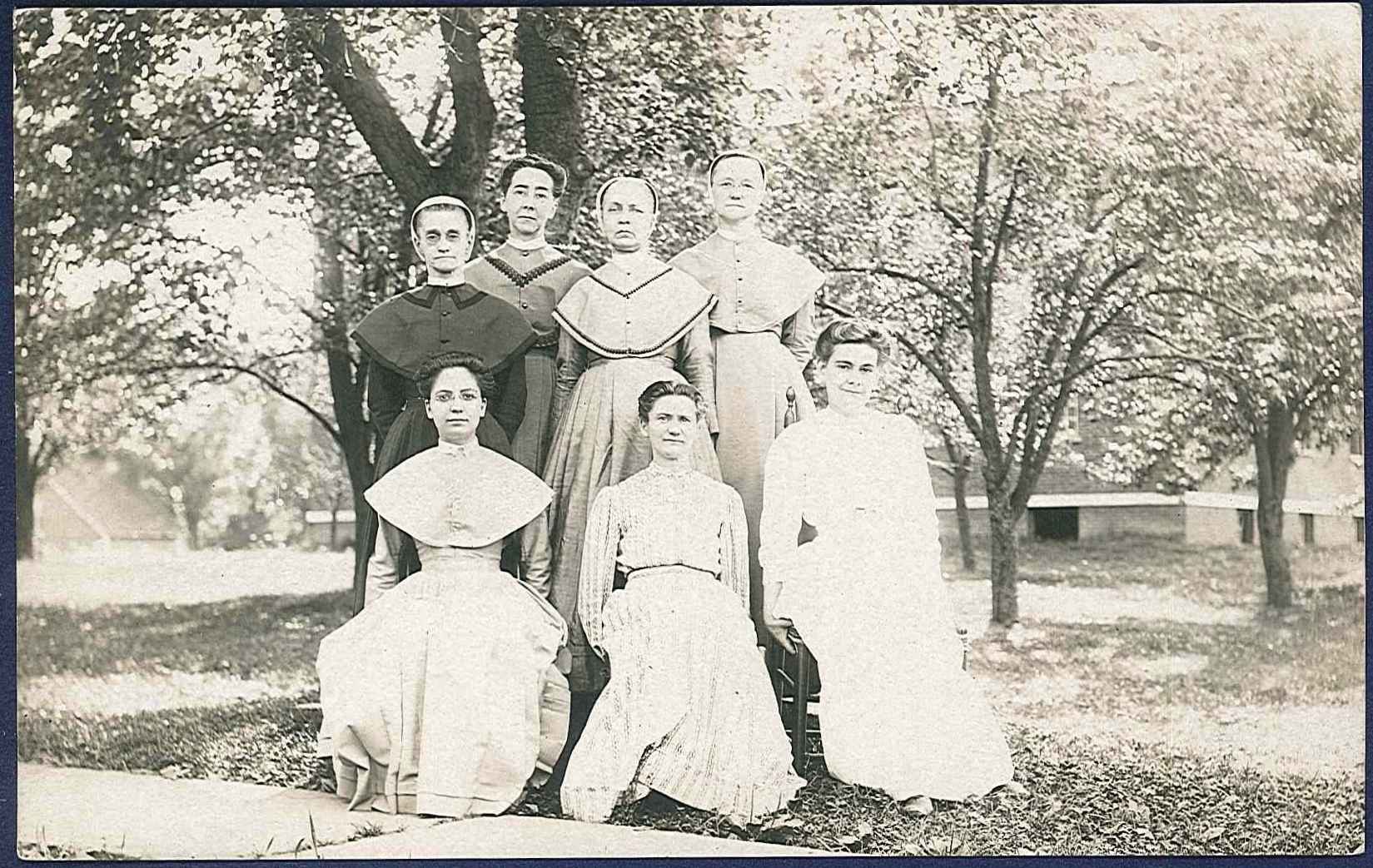 A group of women in dresses posing for a photo.