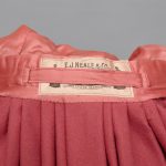 A pink silk dress with a label on it.