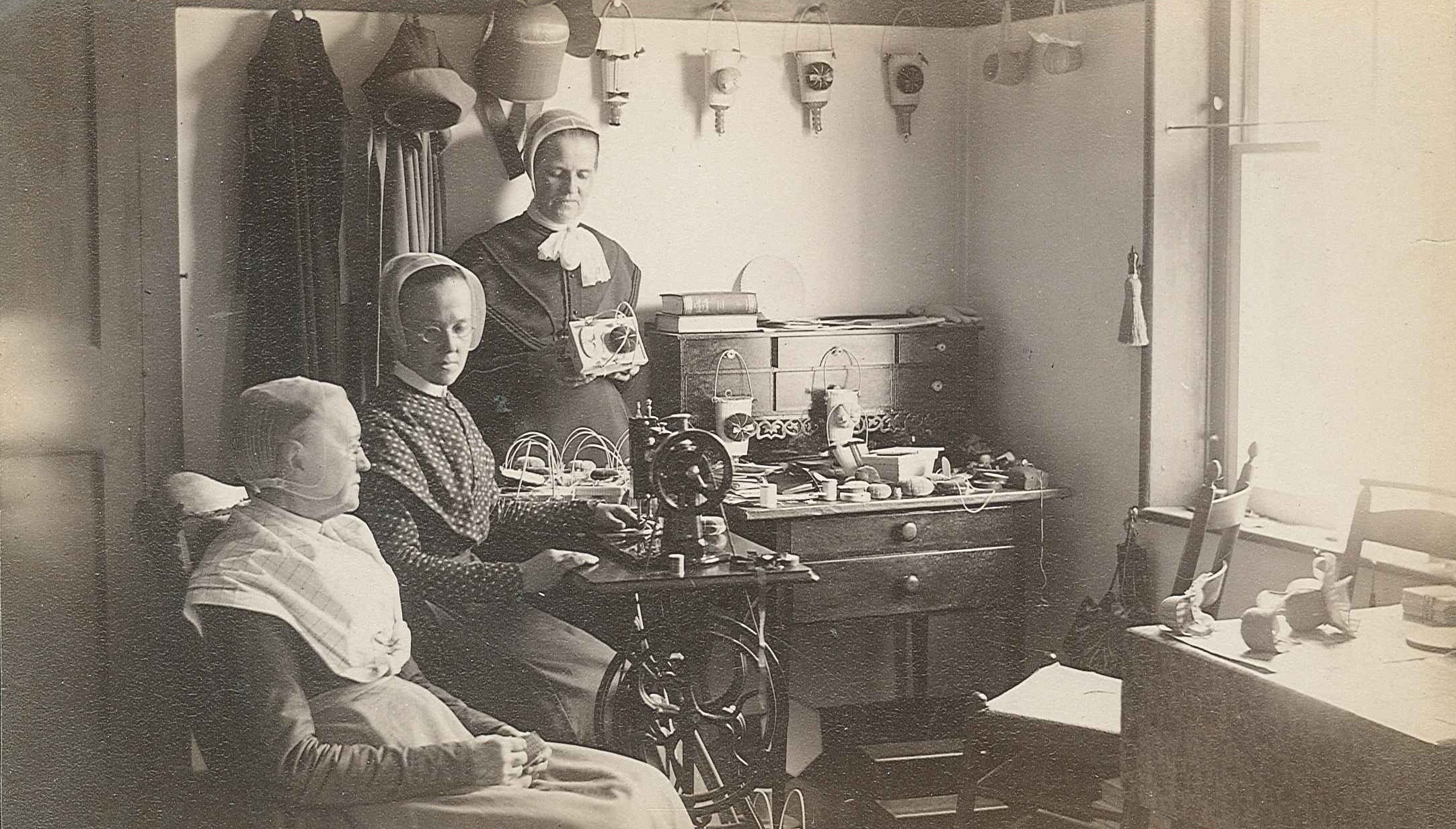 Three women in a room with a sewing machine.