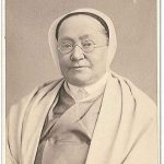 An old photo of a woman in a white robe.