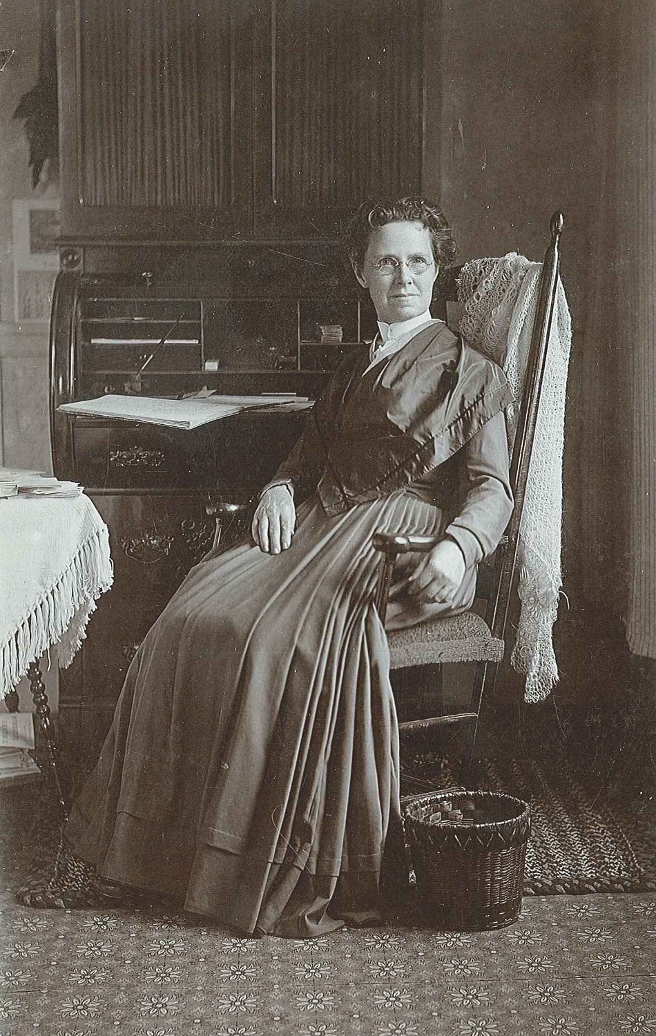 An old photo of a woman sitting in a chair.