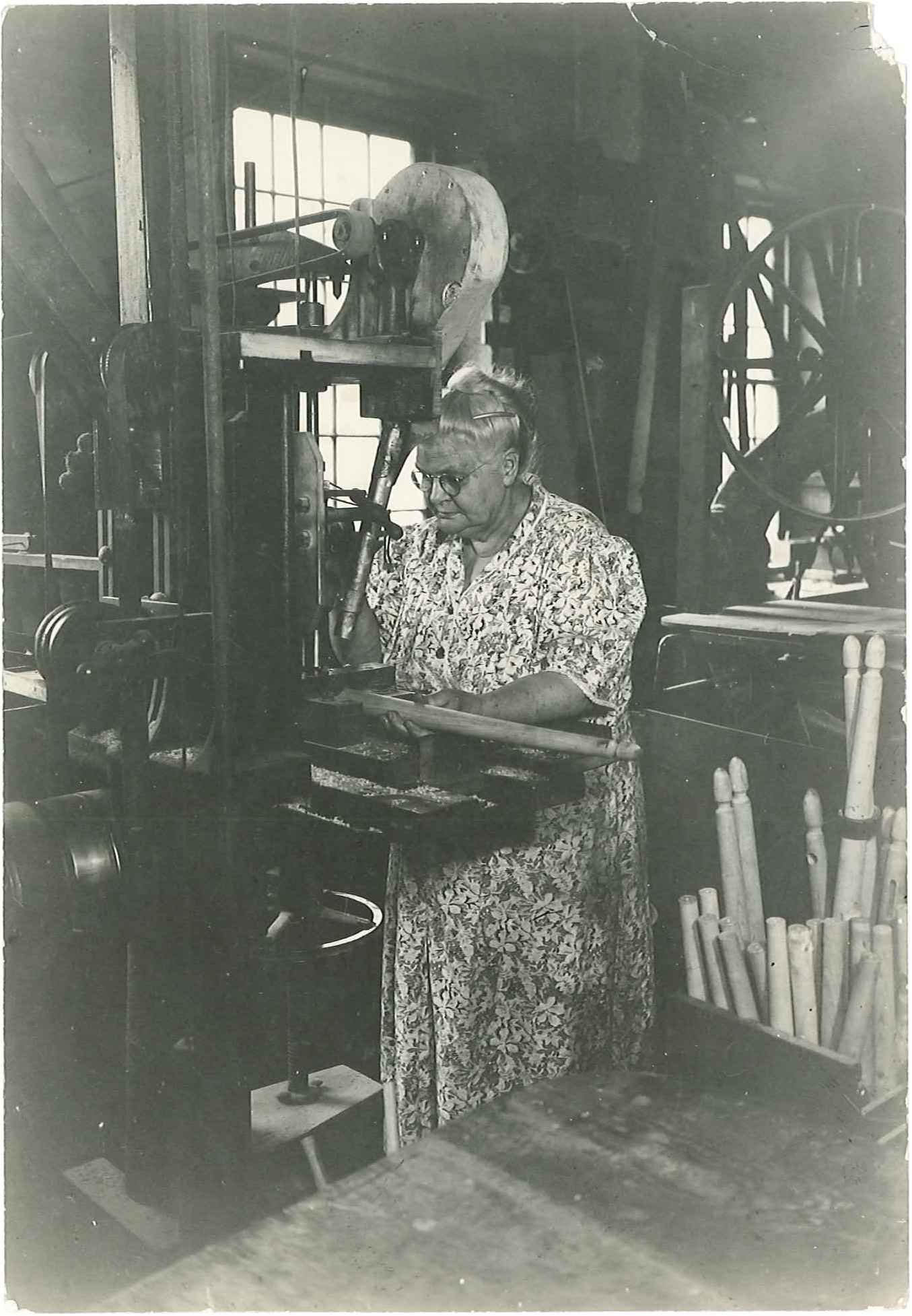 An old photo of a woman working in a factory.