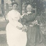 Two women sitting on a bench.