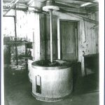 An old black and white photo of a machine in a room.