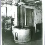 An old black and white photo of a machine in a room.