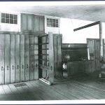 An old photo of a room with wooden floors.