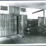 An old photo of a room with wooden floors.