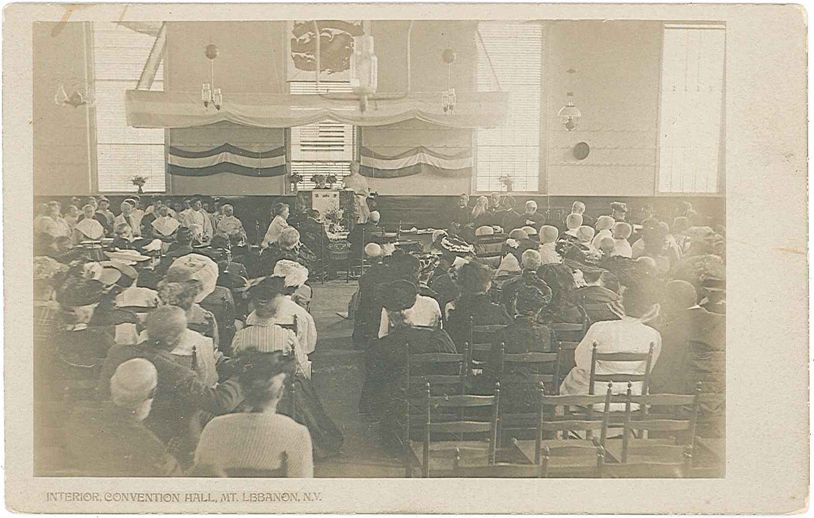 An old photo of a church with people sitting in the pews.