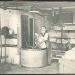 An old photo of a man working in a factory.