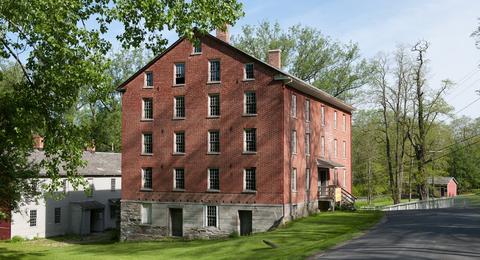 A red brick building sits on the side of a road.