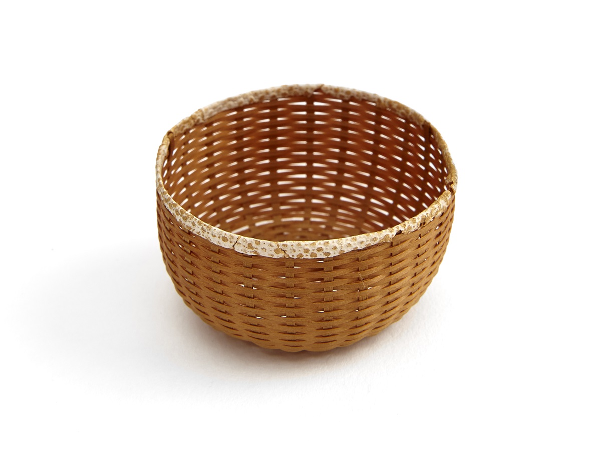 A small wicker basket on a white surface.