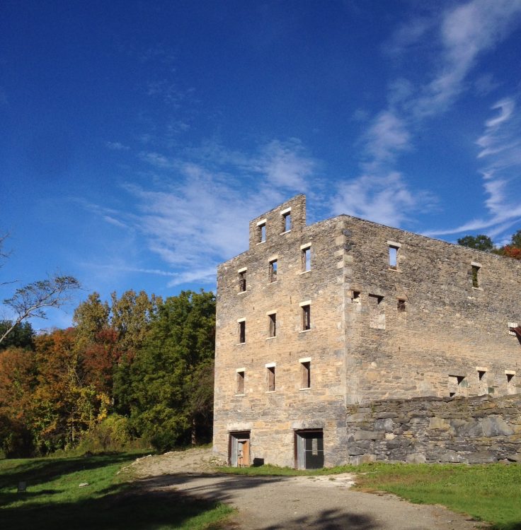 An old stone building in the middle of a field.