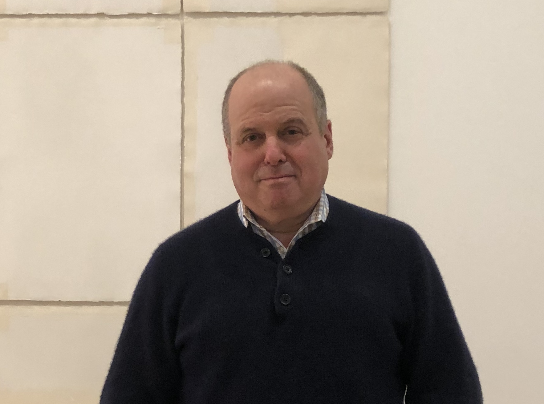 A man standing in front of a white wall.