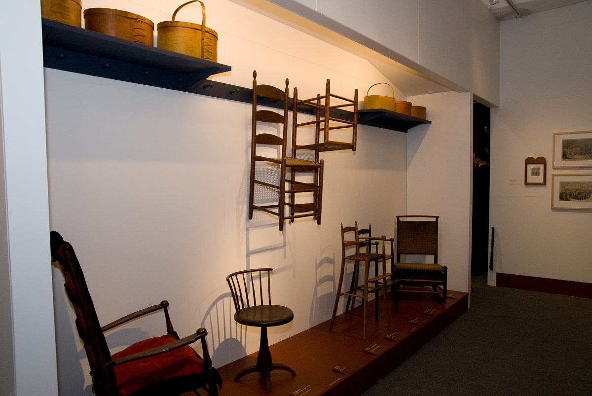 A display of chairs and baskets in a museum.