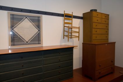 A dresser and a chair in a room.