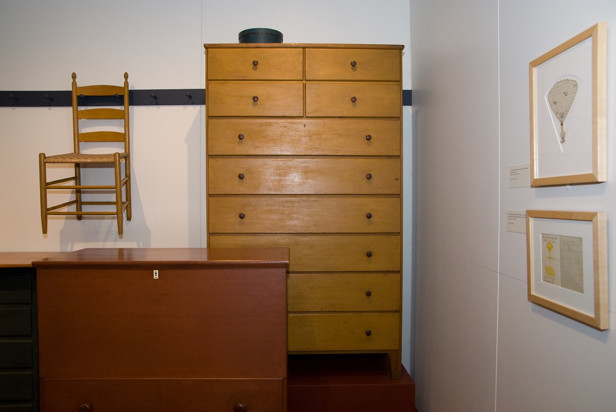 A wooden chest of drawers in a room.