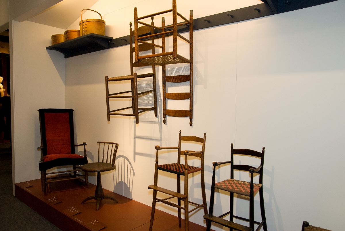 A group of wooden chairs in a museum.